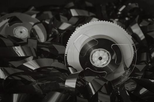 Close-up black and white photo of retro cassette tape and plastic spools.