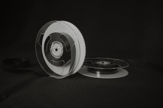 Close-up of a vintage reel-to-reel audio tape on a black background, showcasing retro recording technology.