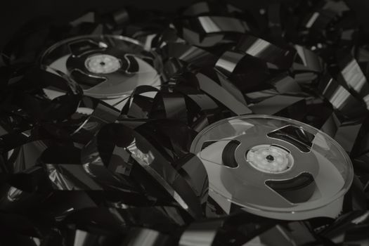 High-angle view of vintage cassette tapes with tangled recording tape, emphasizing a retro aesthetic.
