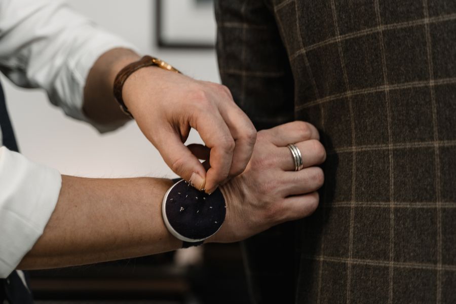 A tailor adjusting the details of a suit jacket