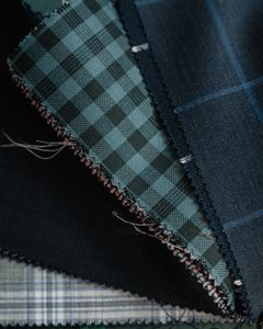 Detailed close-up of assorted plaid and checkered fabrics, showcasing textile textures and patterns.