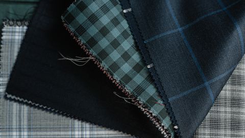 Detailed close-up of assorted plaid and checkered fabrics, showcasing textile textures and patterns.