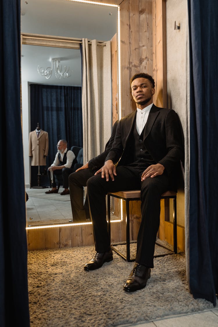 Man In Black Suit Sitting On Chair