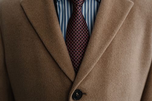 Free Close-up of a sophisticated brown wool coat over a striped shirt and patterned tie. Stock Photo