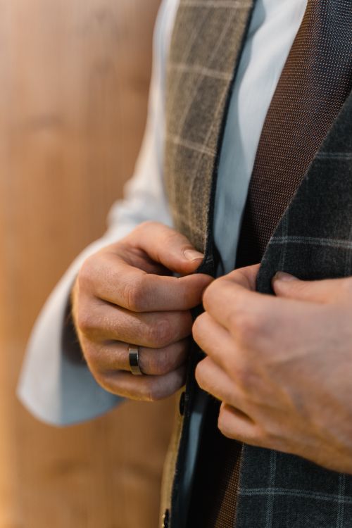 Free Close-up of a man's hands buttoning a stylish tailored suit, showcasing elegance and craftsmanship. Stock Photo