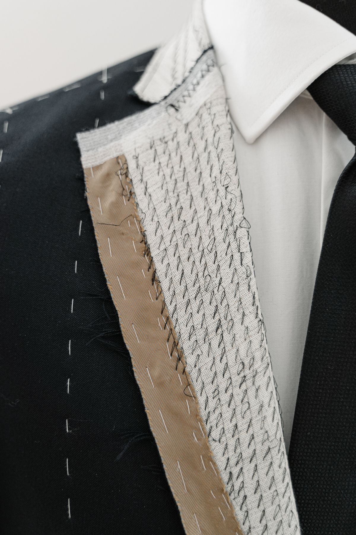 The unfinished lapel of a suit jacket during a fitting