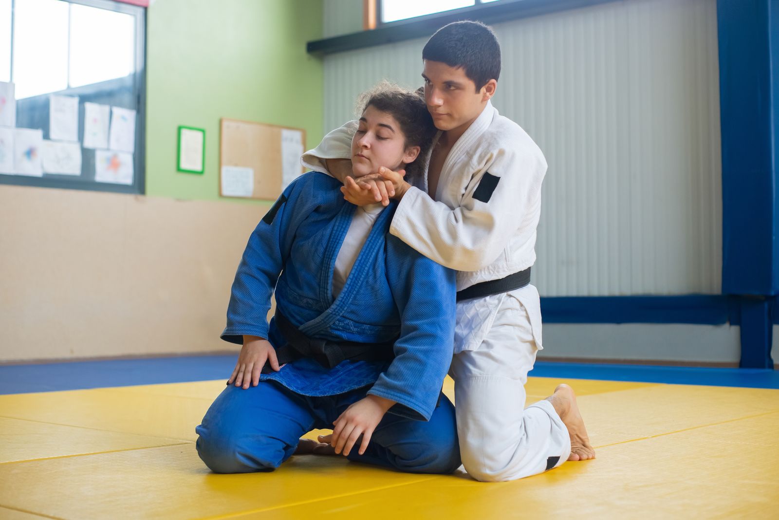 Brazilian jiu-jitsu grappling on mats with knees visible, matching a BJJ hinged knee brace selector. Photo: Pexels.