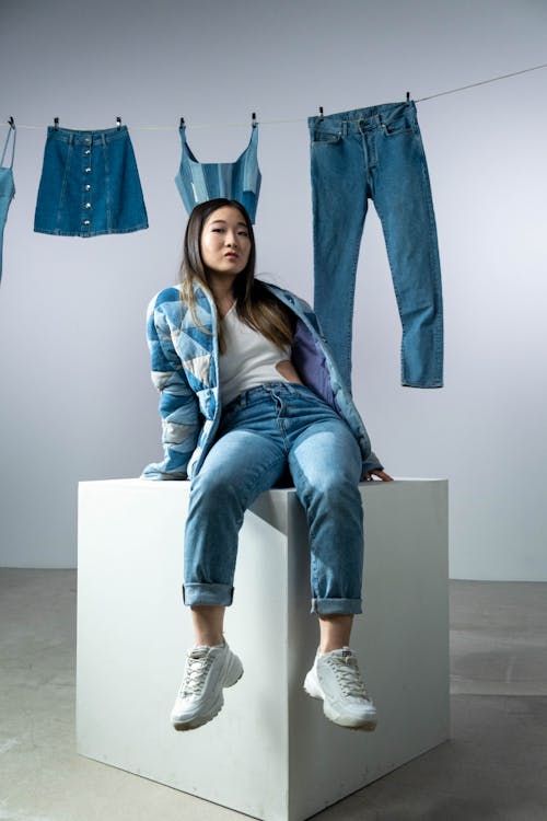 Woman Wearing Denim Clothes Sitting on a Box