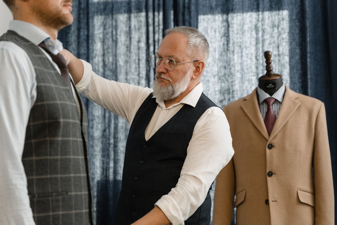 A tailor measuring a client with a tape measure