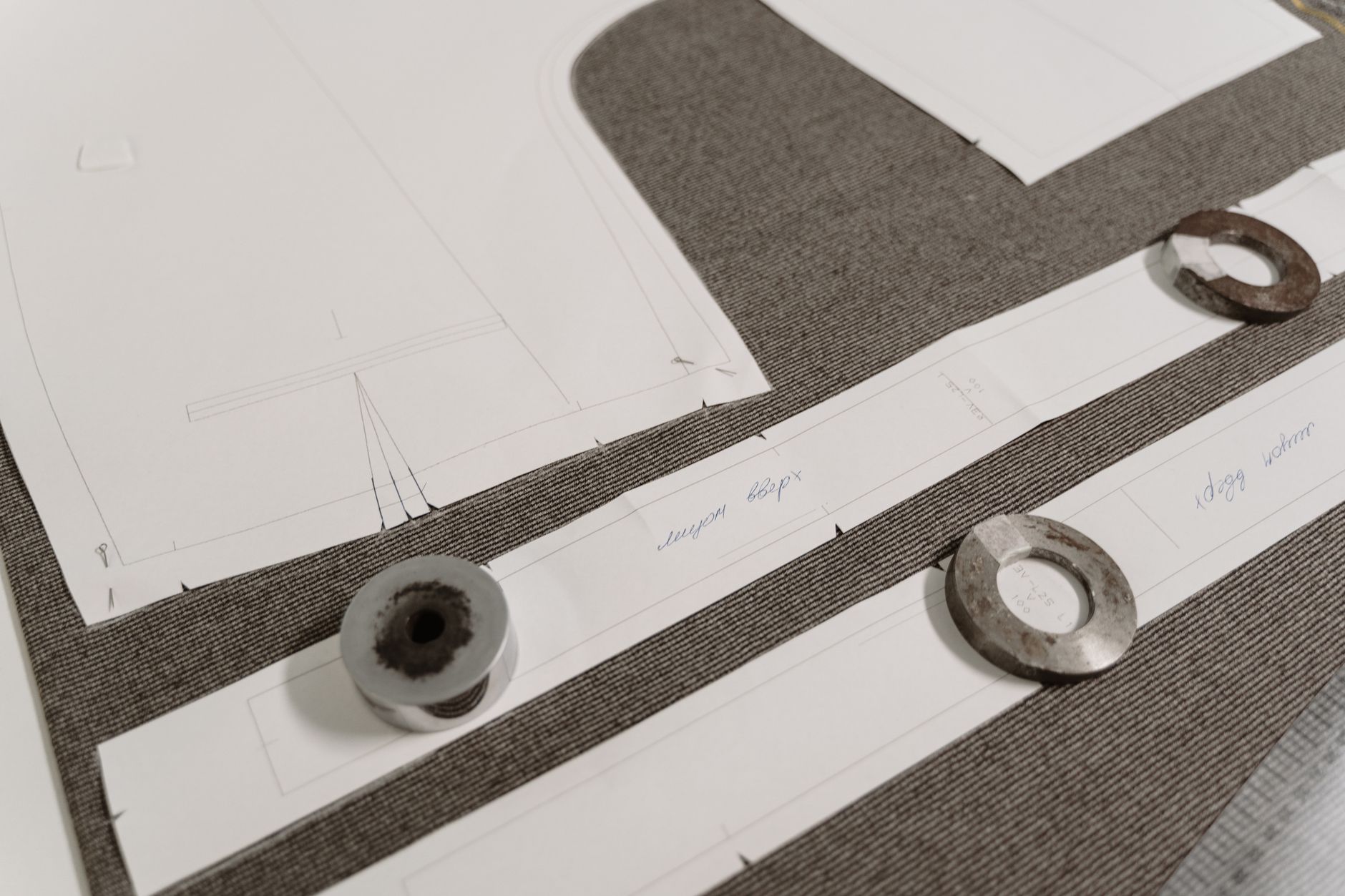 A refined composition of architectural blueprints and rare material swatches in a minimalist luxury atelier setting.