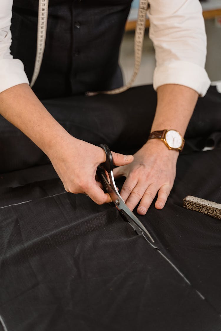 Tailor Cutting A Black Fabric