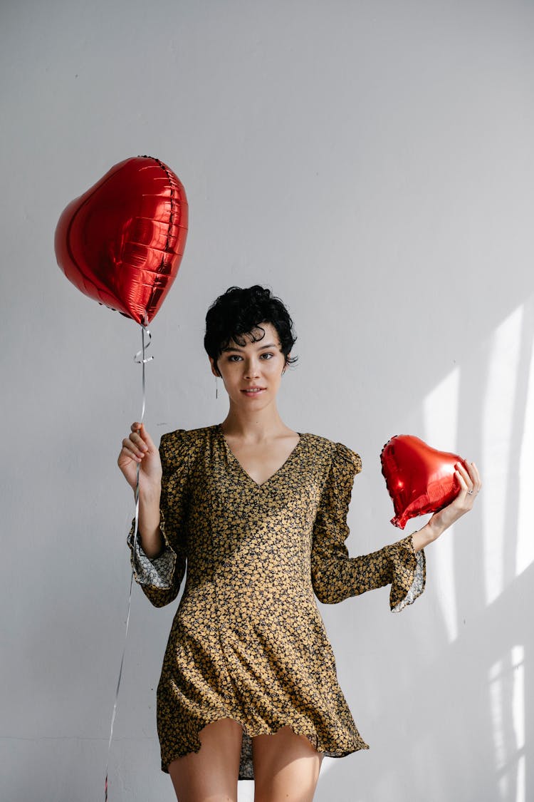 Beautiful Woman Holding Two Red Heart-shaped Balloons 