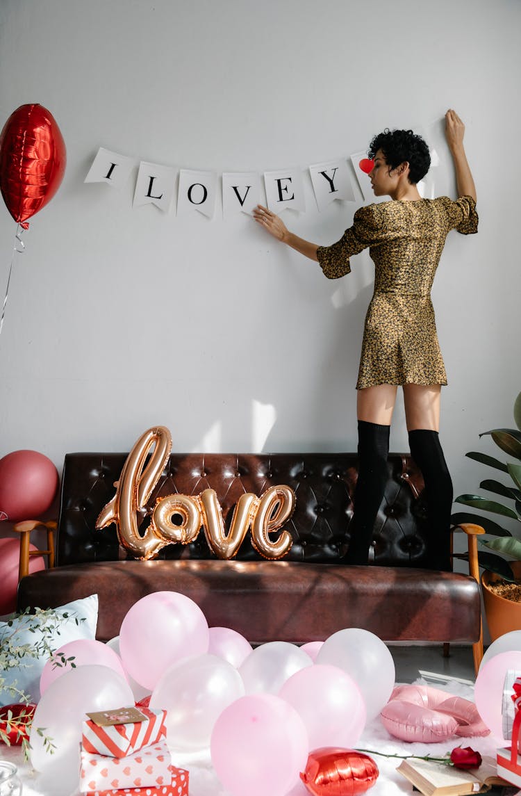 Stylish Woman Decorating Lounge For Saint Valentine Day