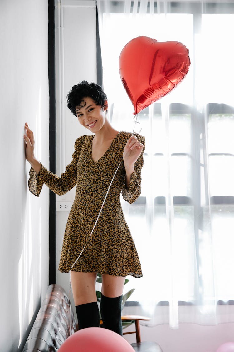 Smiling Female Standing With Heart Shaped Balloon