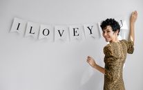 Happy woman decorating wall with inscription I Love You
