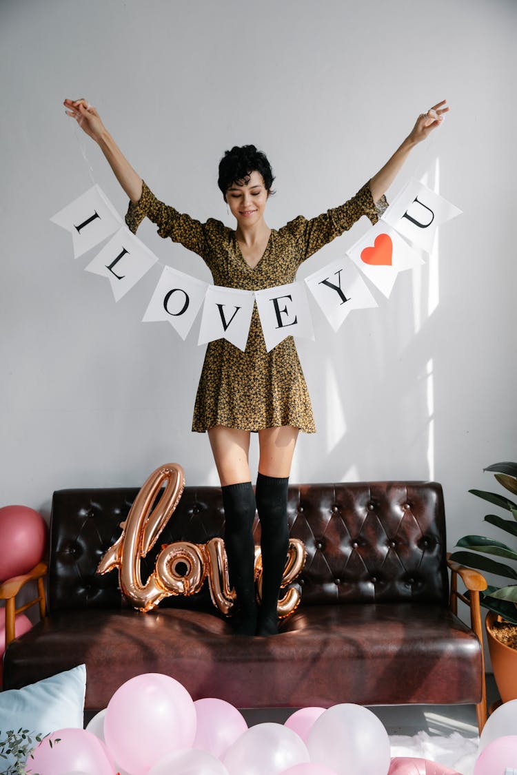 Woman Standing With Love Inscription In Raised Arms