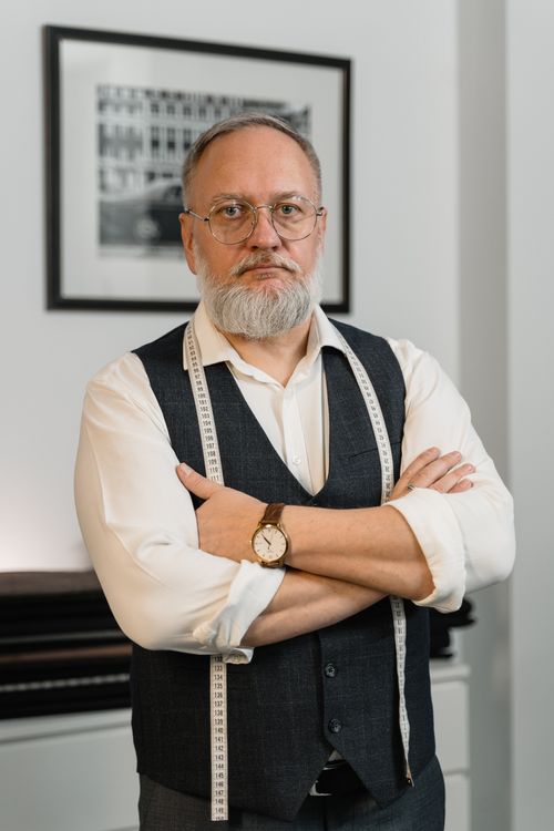 Free Elderly male fashion designer standing confidently in a stylish atelier. Stock Photo