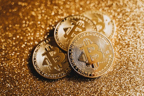 Close-up of Bitcoin Coins in Golden Glitter Background 