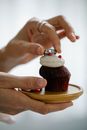 Faceless lady putting Love engraved ring on delicious muffin