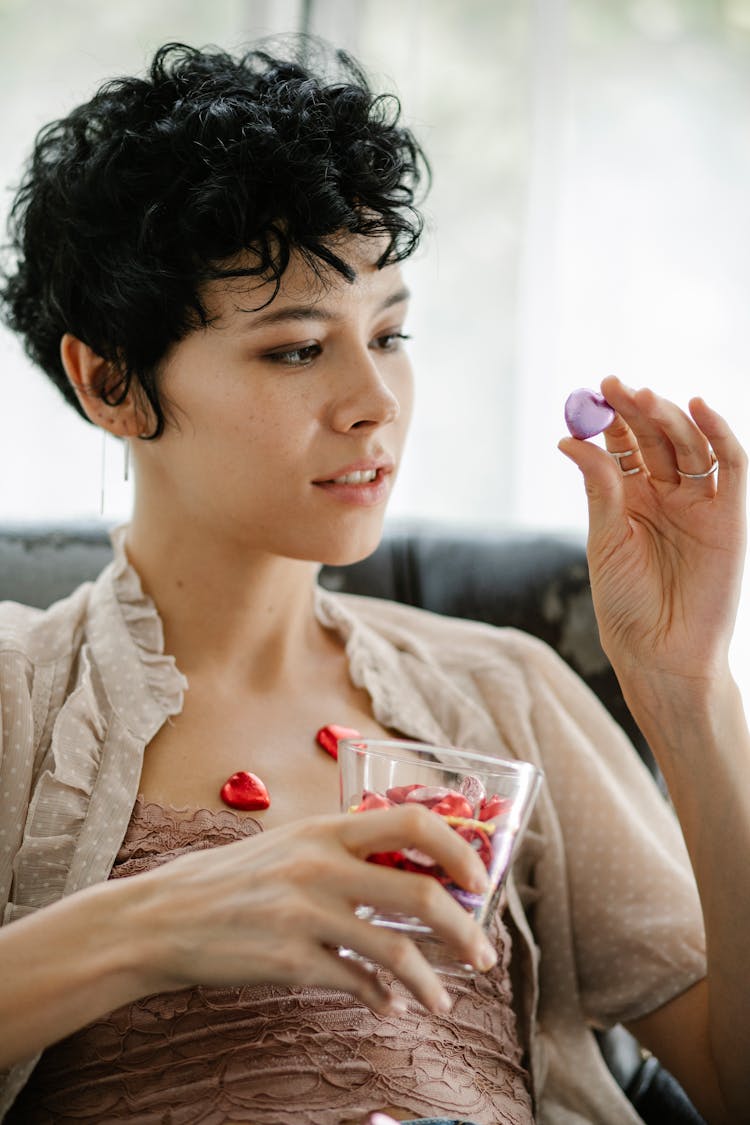 Positive Young Woman Eating Tasty Chocolate Candies At Home