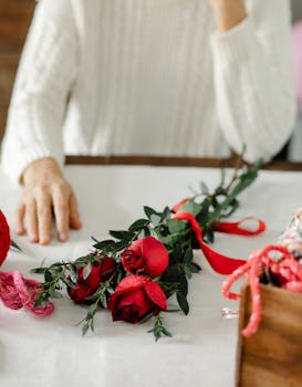 Elegant red rose bouquet tied with ribbon on table, perfect for gift or decoration.