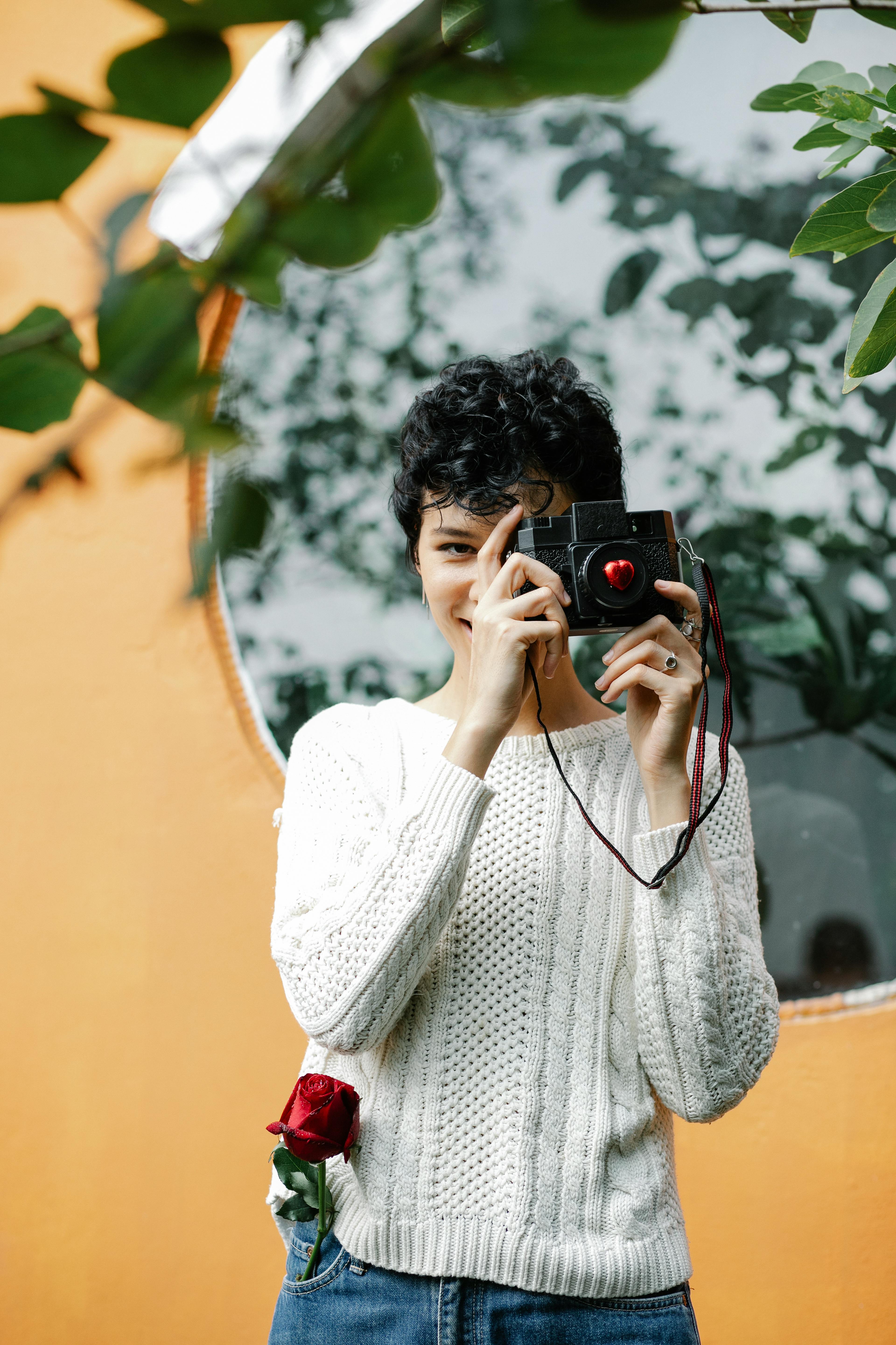 Cheerful woman taking photo with camera