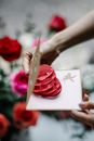 Crop anonymous female demonstrating pop up gift card with heart and Cupid with bow symbols during festive occasion
