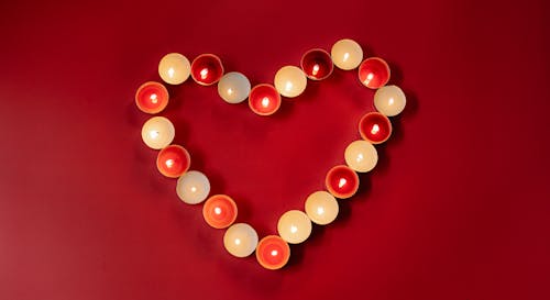 Colorful heart shaped burning candles