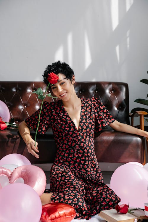Elegant woman with rose near balloons