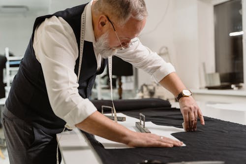 A Tailor Marking a Black Fabric
