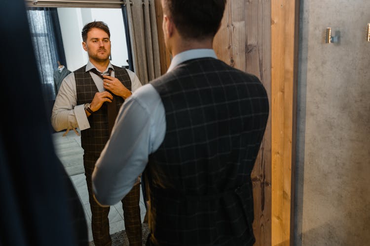 A Man With A Waistcoat Looking At A Mirror