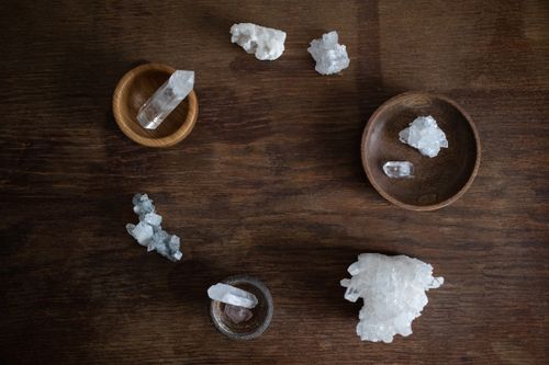 Free A flat lay of clear quartz crystals arranged on wooden bowls against a dark wooden background. Stock Photo
