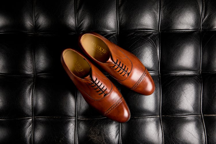 A Pair Of Brown Oxford Shoes On Black Surface