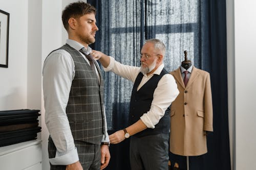 A Tailor Taking Body Measurement of Man in Gray Button Up Shirt