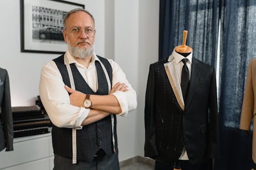 Man in Black Vest Standing Beside Mannequin Wearing Black Suit 