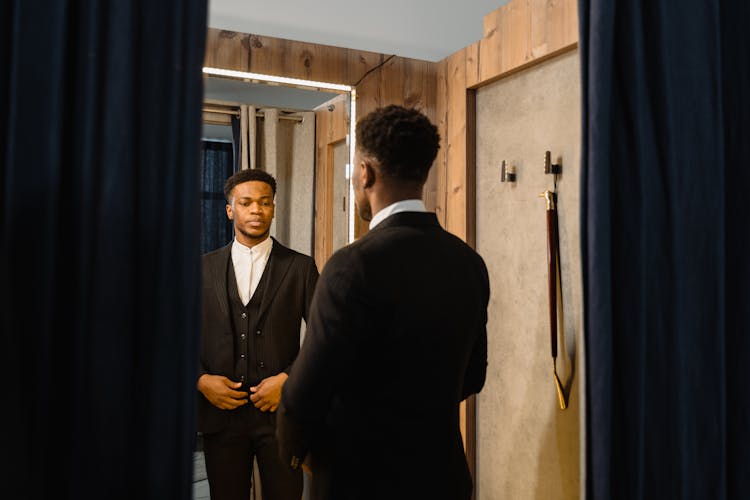 Man In Black Suit Looking At The Mirror