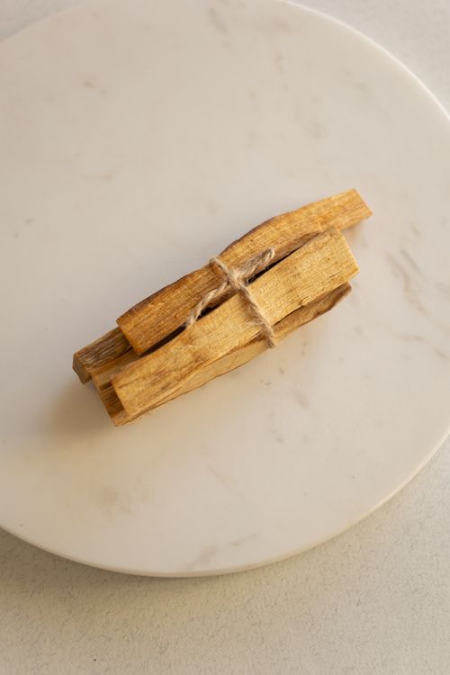 Free A top view of tied Palo Santo sticks placed on a round marble plate. Ideal for wellness themes. Stock Photo