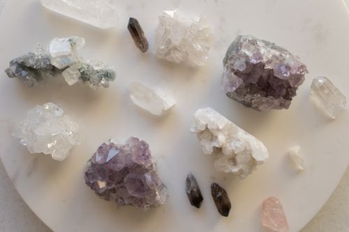 Free A variety of natural crystals including amethyst and quartz arranged on a white surface. Stock Photo