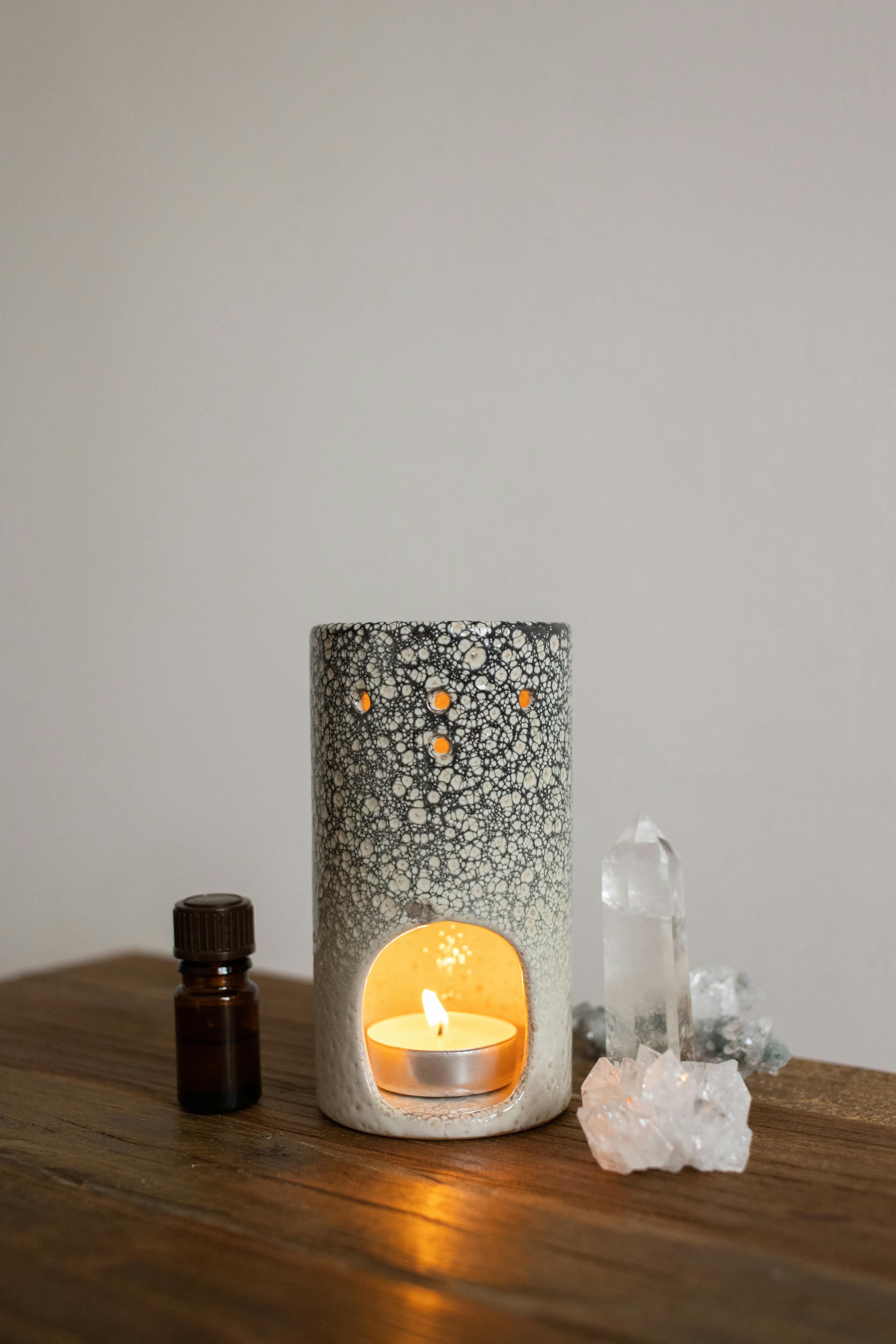 Aesthetic candle arrangement with crystals and essential oil, perfect for relaxation.