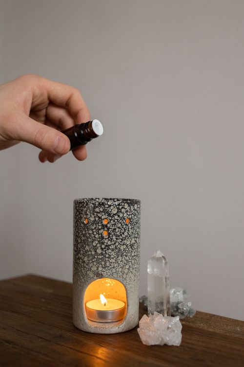 Free A cozy aromatherapy scene with candle holder, essential oil, and crystals creating a calm atmosphere. Stock Photo