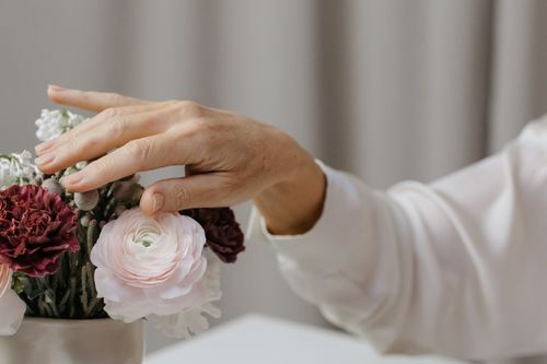 Free Close-up of a hand gracefully arranging a bouquet of fresh flowers, showcasing natural beauty. Stock Photo