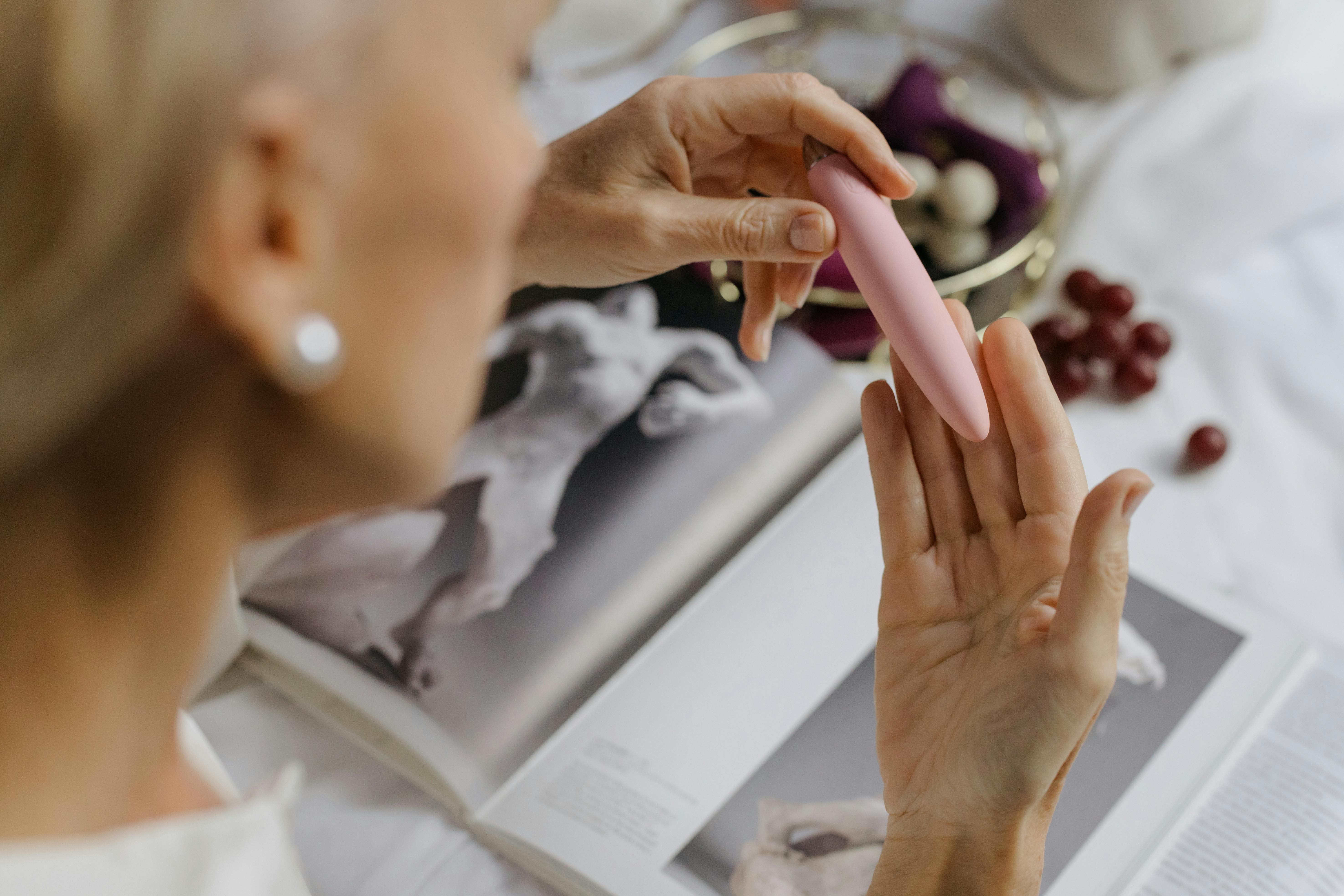 woman holding pink dildo in hands