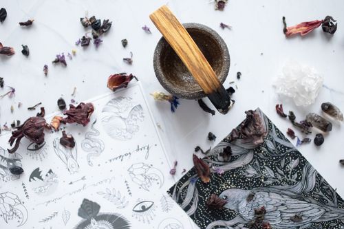 Free Artistic flat lay of a rustic bowl, drawings, and dried petals on a white marble surface. Stock Photo