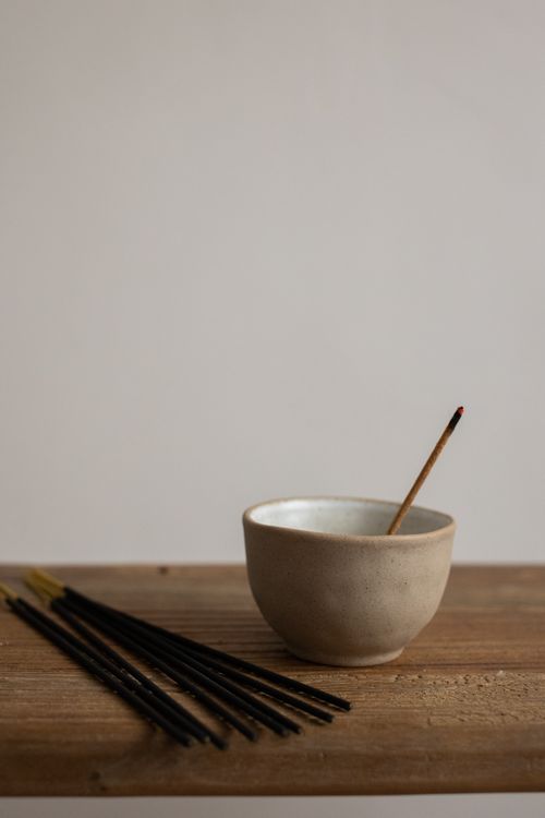 Free Minimalist setup of incense sticks and a ceramic bowl on wooden surface for relaxation. Stock Photo