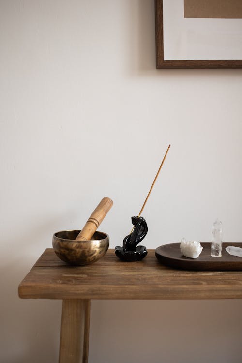 Incense Stick, Crystals and a Mortar and a Pestle on a Wooden Table