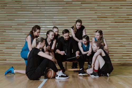 A Man Coaching a Team of Women