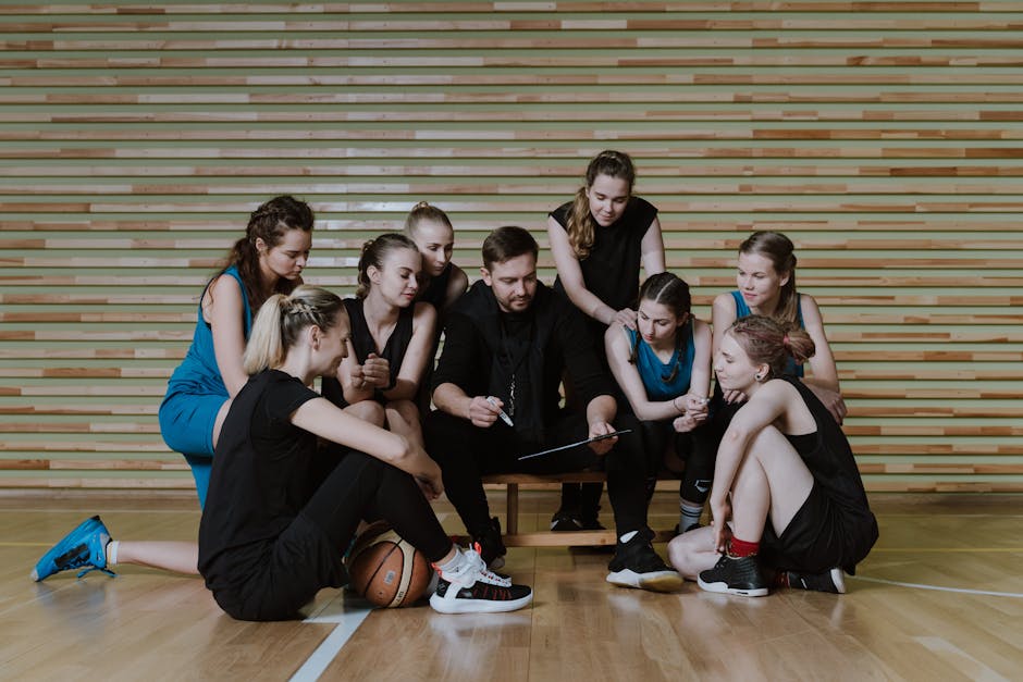 Urapolut ja erikoistuminen Urapolut ja erikoistuminen - A coach strategizes with a women's basketball team in a gymnasium.