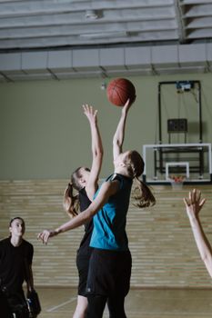 Dynamic indoor basketball game showcasing women athletes in action on court.
