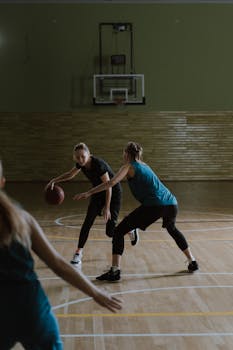 Women basketball players competing on an indoor court.
