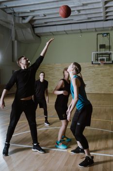 Dynamic scene of players engaged in an indoor basketball game.